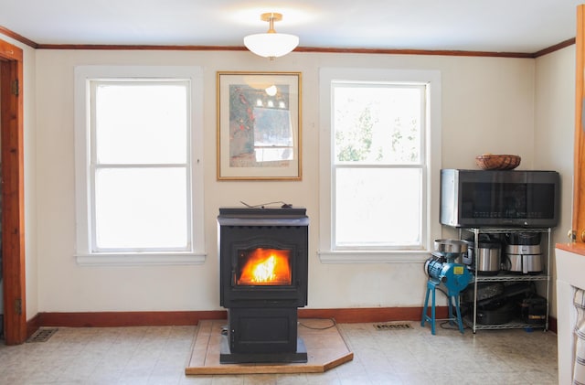 sitting room with crown molding and a wood stove