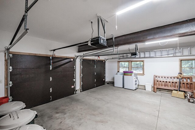 garage with a garage door opener and washing machine and dryer