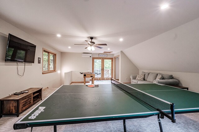 recreation room featuring ceiling fan, light colored carpet, vaulted ceiling, and a wall mounted AC