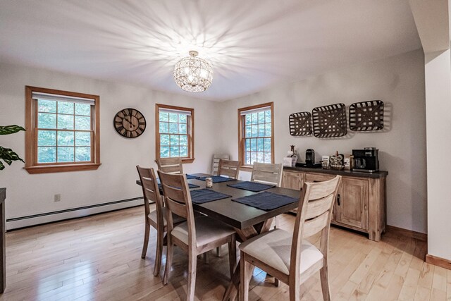 dining space featuring a notable chandelier, baseboard heating, and light wood-type flooring