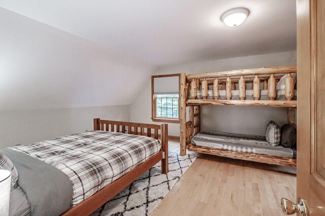 bedroom featuring light hardwood / wood-style flooring and lofted ceiling