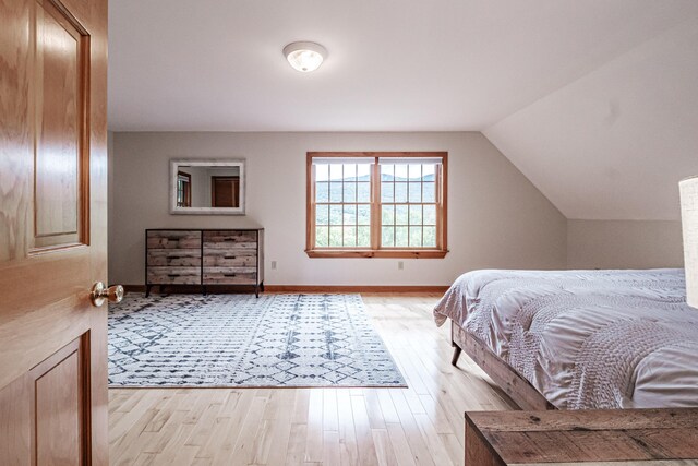 bedroom featuring light wood-type flooring and lofted ceiling