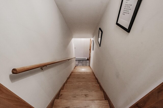 staircase featuring wood-type flooring and baseboard heating