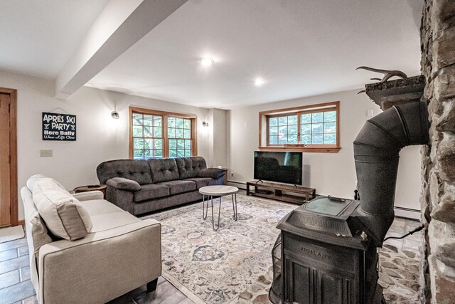 living room with a baseboard heating unit, a wealth of natural light, and beamed ceiling