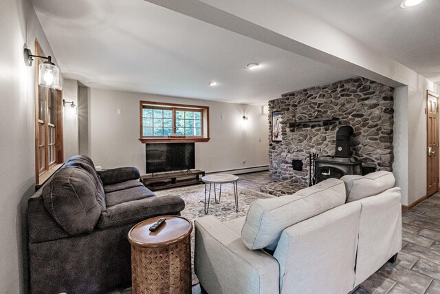 living room with a baseboard heating unit and a wood stove