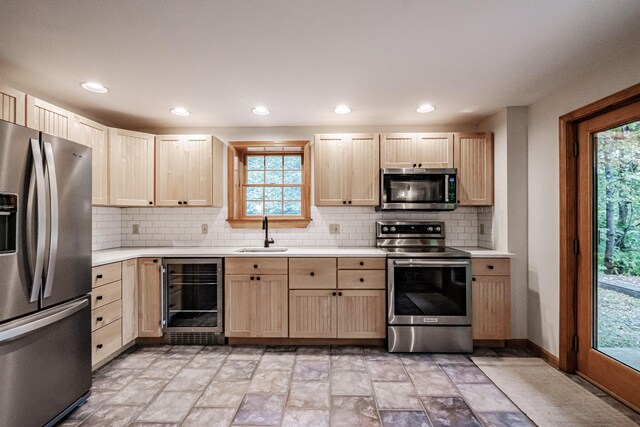 kitchen with stainless steel appliances, wine cooler, plenty of natural light, and sink