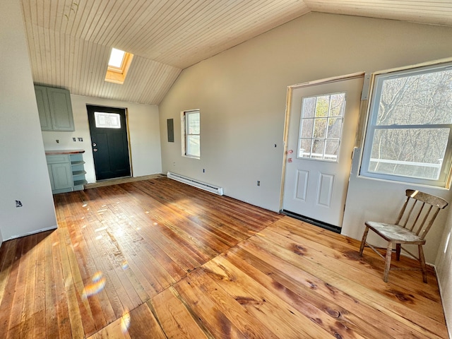 foyer entrance featuring baseboard heating, vaulted ceiling with skylight, wood ceiling, and light wood-type flooring