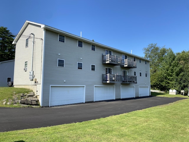 back of house featuring a balcony and a garage