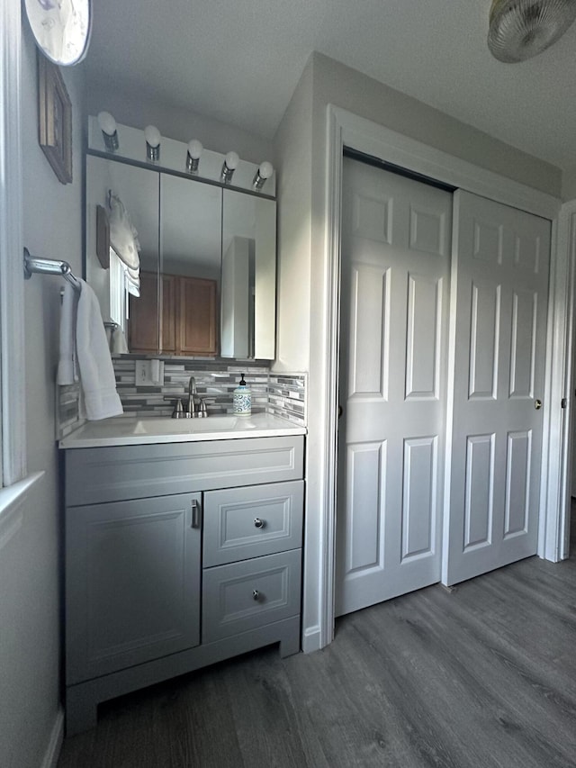 bathroom with hardwood / wood-style floors, tasteful backsplash, and vanity