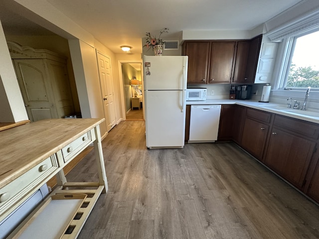 kitchen featuring light wood-type flooring, white appliances, dark brown cabinetry, and sink