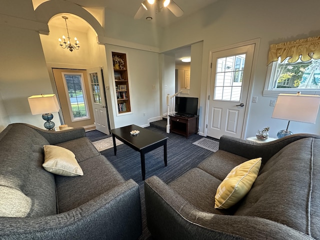 living room featuring ceiling fan with notable chandelier