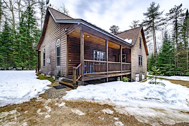 chalet / cabin with an attached garage and covered porch