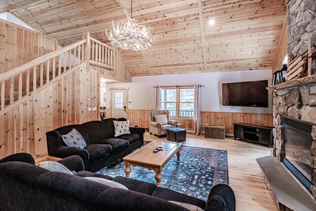 living room with wood ceiling, wooden walls, light hardwood / wood-style flooring, high vaulted ceiling, and a fireplace