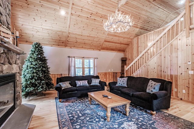 living room with wood finished floors, wood walls, wooden ceiling, and stairway