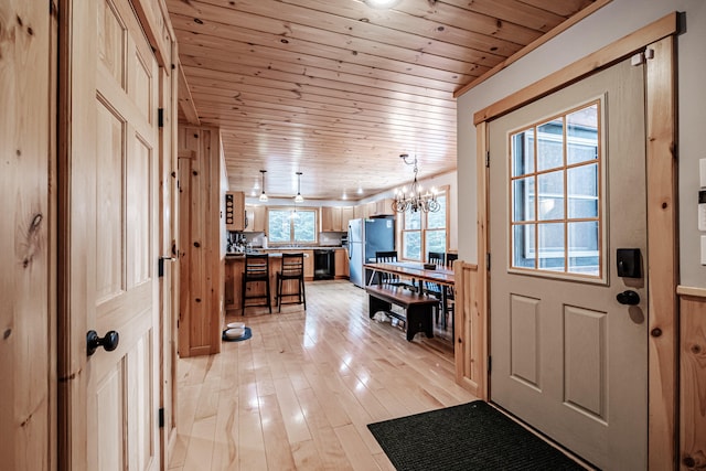 entrance foyer featuring wood walls, a chandelier, crown molding, wooden ceiling, and light hardwood / wood-style flooring