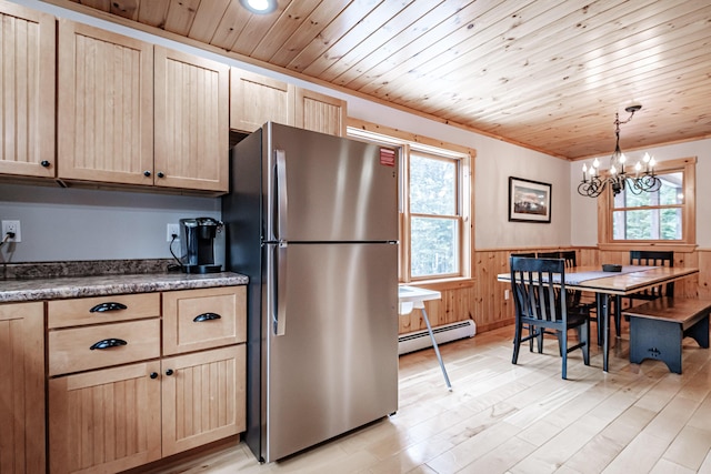 kitchen with freestanding refrigerator, a wainscoted wall, a chandelier, a baseboard radiator, and light brown cabinets
