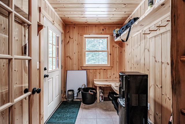 mudroom featuring light tile patterned flooring, wooden walls, wooden ceiling, and a healthy amount of sunlight