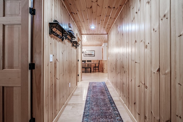 hallway with wood walls and wooden ceiling