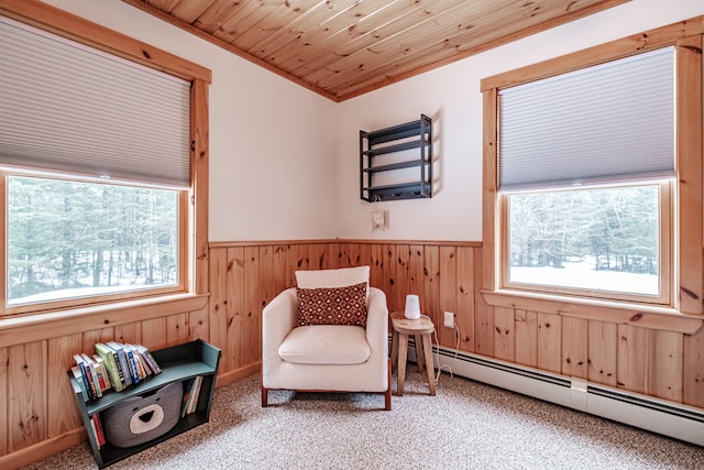 sitting room with carpet floors, a baseboard radiator, wood ceiling, and a healthy amount of sunlight