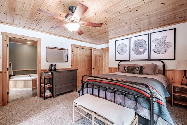 carpeted bedroom with wooden walls, a closet, wooden ceiling, and a wainscoted wall