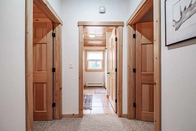hall featuring baseboards, wooden ceiling, light colored carpet, and baseboard heating