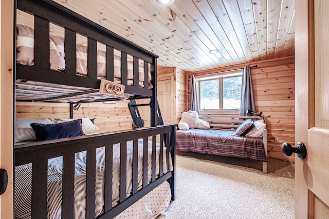 bedroom with wood ceiling, wood walls, and carpet flooring