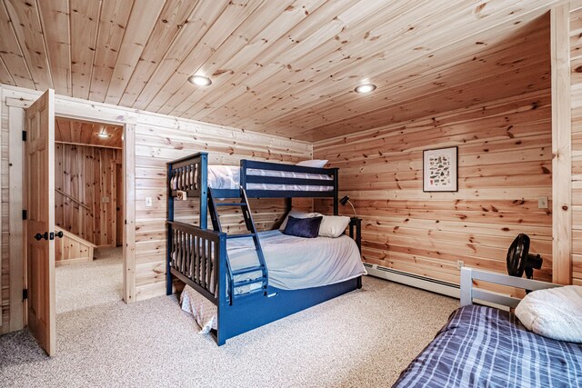 bedroom featuring wood walls, wood ceiling, carpet, and a baseboard radiator