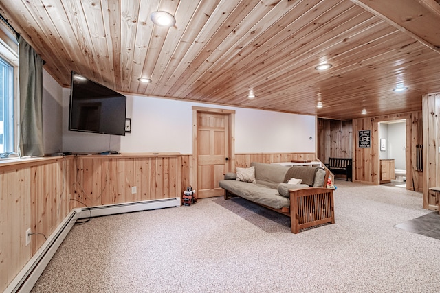 carpeted living room featuring wooden walls, a baseboard radiator, and wooden ceiling