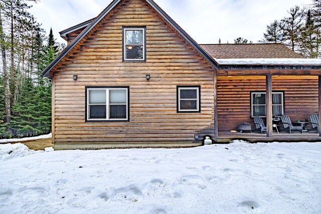 view of snow covered back of property