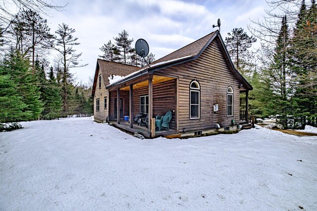 view of snow covered exterior featuring covered porch