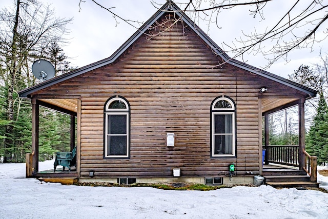 snow covered property featuring covered porch