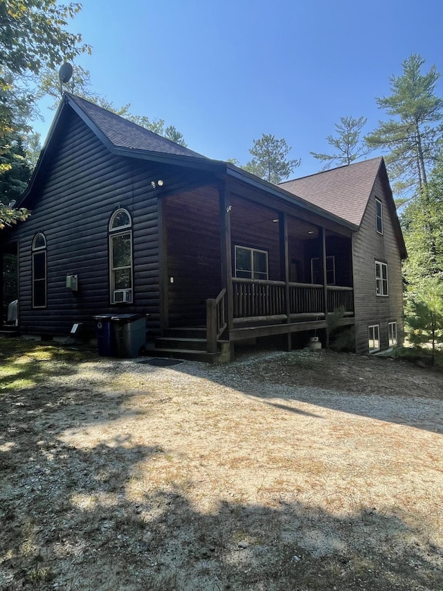 view of home's exterior featuring a shingled roof and faux log siding