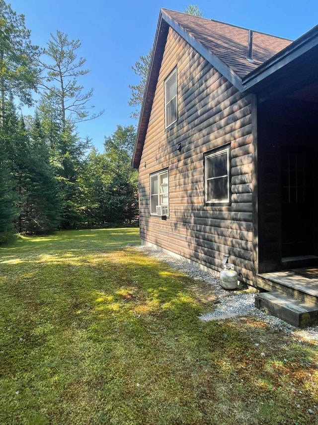 view of side of home featuring cooling unit and a lawn