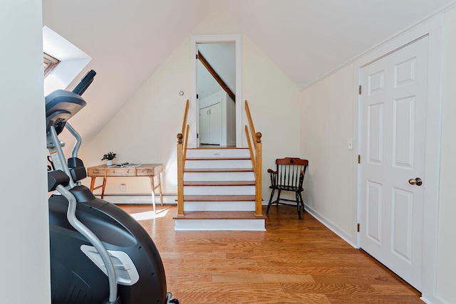 interior space featuring a baseboard radiator, vaulted ceiling, and light hardwood / wood-style floors