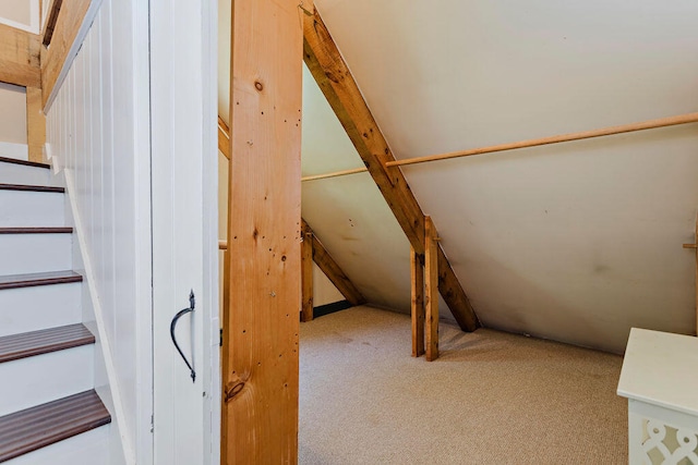 stairway with lofted ceiling and carpet