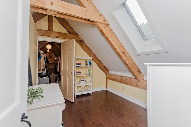 additional living space with dark hardwood / wood-style floors and vaulted ceiling with skylight