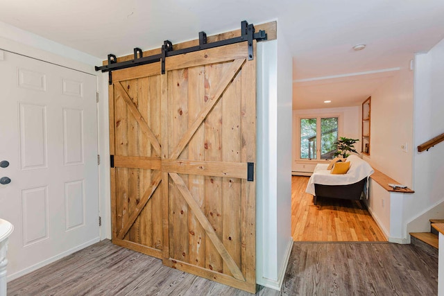 corridor with a barn door and hardwood / wood-style floors