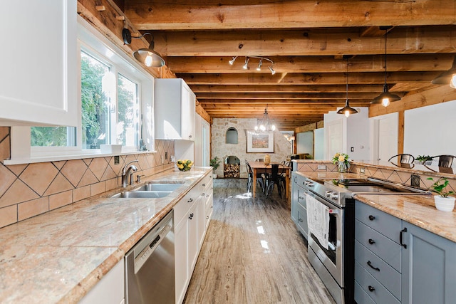 kitchen with pendant lighting, white cabinetry, appliances with stainless steel finishes, and beam ceiling