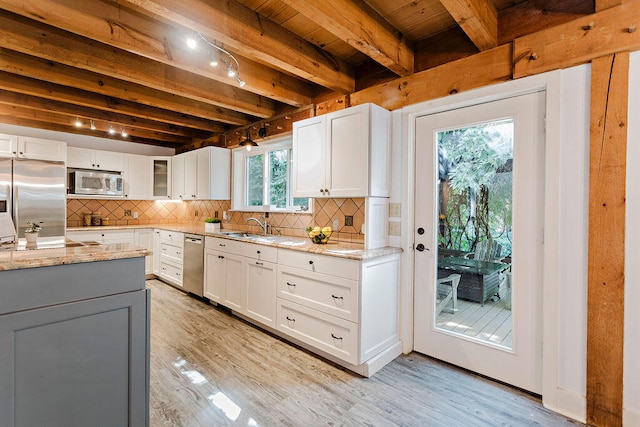 kitchen featuring light stone counters, stainless steel appliances, and white cabinets