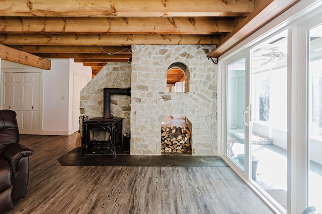 unfurnished living room featuring wood-type flooring, beamed ceiling, and a wood stove