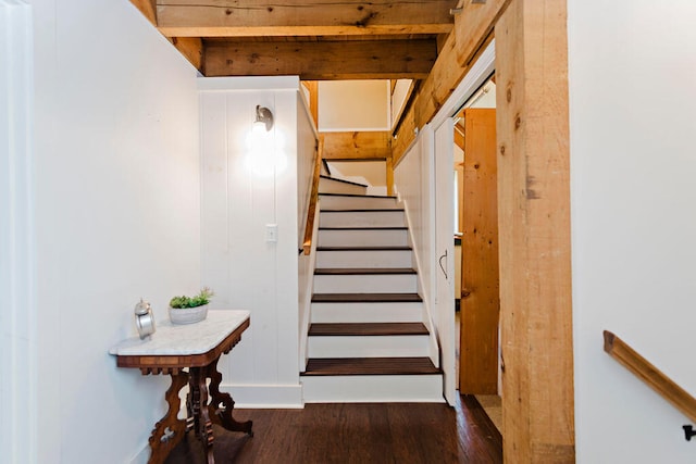 stairway with hardwood / wood-style flooring and beam ceiling