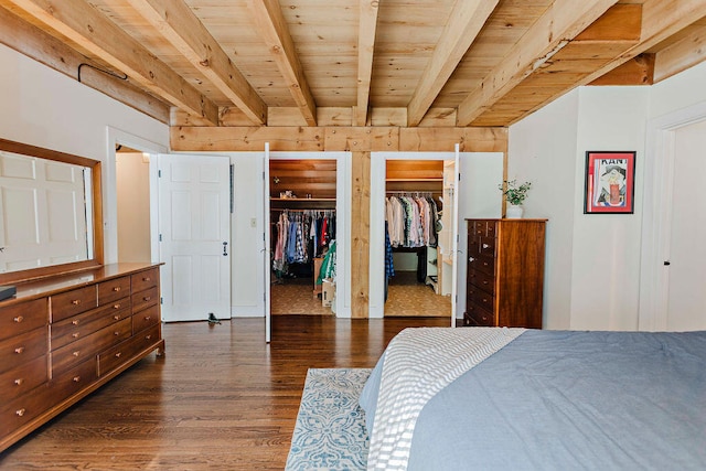 bedroom featuring beamed ceiling, dark hardwood / wood-style floors, two closets, and wooden ceiling