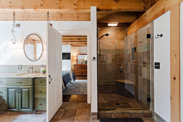 bathroom featuring beamed ceiling, vanity, and an enclosed shower