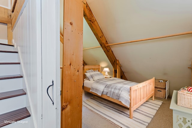 carpeted bedroom with vaulted ceiling with beams