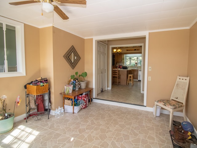 living area with crown molding and ceiling fan