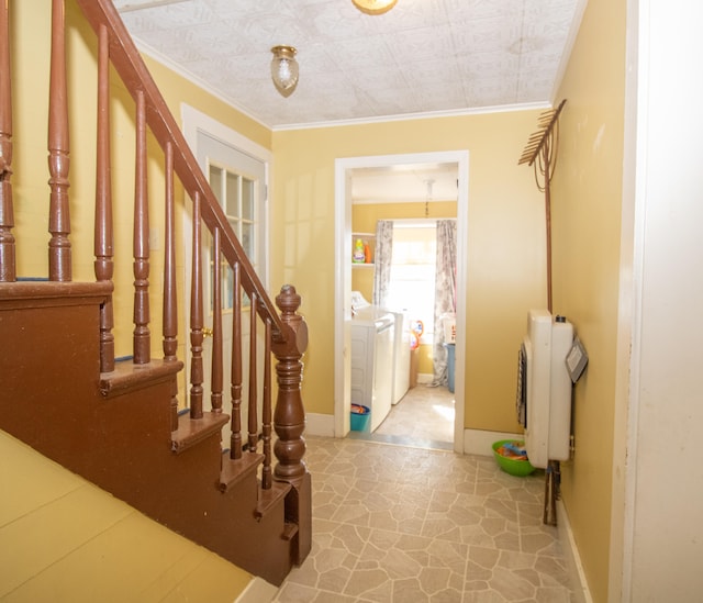 entrance foyer with ornamental molding, radiator, light tile patterned floors, and washing machine and clothes dryer