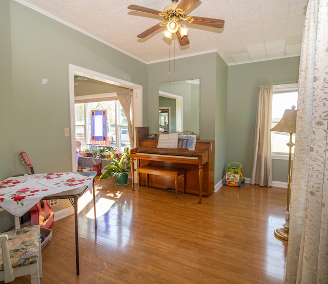 dining area with crown molding, ceiling fan, and light wood-type flooring