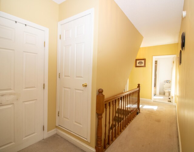 corridor featuring light colored carpet