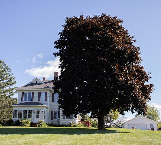 view of front facade with a playground, a front yard, and a garage