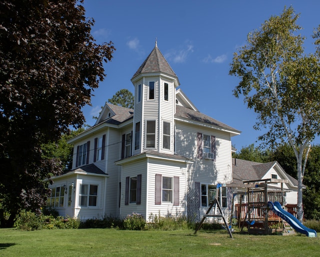 back of property featuring a yard, cooling unit, and a playground